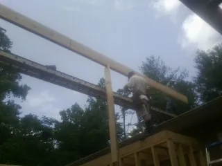 Carpenter setting a ridge beam over a new addition frame — Ice Dam Removal by Roofing Brothers in Moon