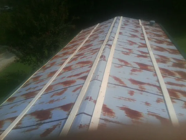 Rusted metal roof panels with new wood purlins before replacement — Storm Damage Roof Repair in Moon by Roofing Brothers